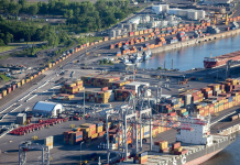 Accident au Port de Montréal : Un autre camionneur décède Vue aérienne du port de Montréal avec des conteneurs et des navires, illustrant l'importance des opérations portuaires pour l'économie canadienne, en lien avec le lock-out des débardeurs.