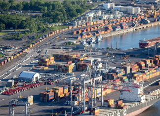 Reprise des activités au port de Montréal : une ordonnance du Conseil canadien des relations industrielles Vue aérienne du port de Montréal avec des conteneurs et des navires, illustrant l'importance des opérations portuaires pour l'économie canadienne, en lien avec le lock-out des débardeurs.