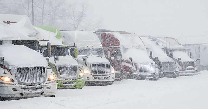 Difficultés lors de tempêtes de neige pour déneiger et déglacer le toit des remorques de camions.