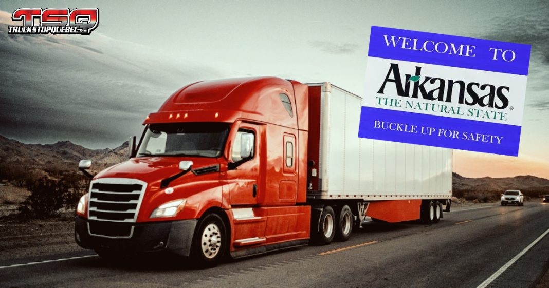 Camion roulant sur une autoroute avec un panneau « Welcome to Arkansas », illustrant le débat sur les camionneurs étrangers et les nouvelles lois proposées en transport routier.