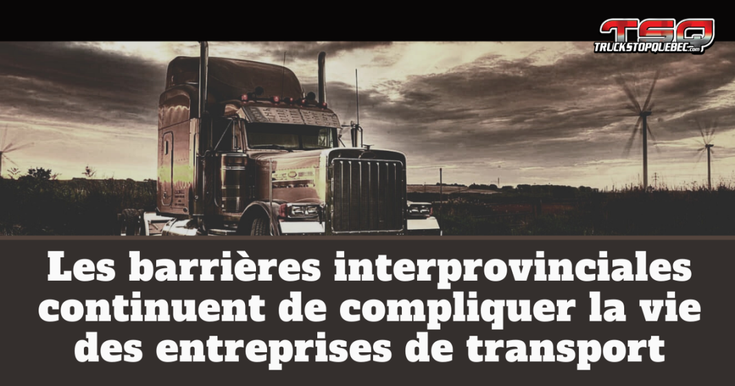 Camion lourd circulant en zone rurale avec des éoliennes en arrière-plan, image illustrant le texte Les barrières interprovinciales continuent de compliquer la vie des entreprises de transport