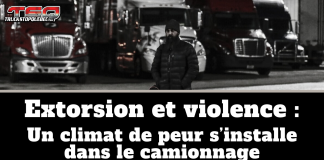 Extorsion et violence : un climat de peur s’installe dans le camionnage Image en noir et blanc d’un homme portant une tuque et un manteau, debout devant une rangée de camions lourds stationnés dans une cour de transport, avec le logo TSQ dans le coin supérieur gauche. Texte sur l’image : « Extorsion et violence : Un climat de peur s’installe dans le camionnage ».