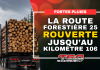 La route forestière 25 rouverte jusqu’au kilomètre 106 Camion forestier chargé de billots circulant sous la pluie, avec l’annonce de la réouverture de la route forestière 25 jusqu’au kilomètre 106.