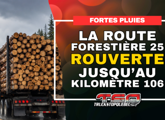 La route forestière 25 rouverte jusqu’au kilomètre 106 Camion forestier chargé de billots circulant sous la pluie, avec l’annonce de la réouverture de la route forestière 25 jusqu’au kilomètre 106.